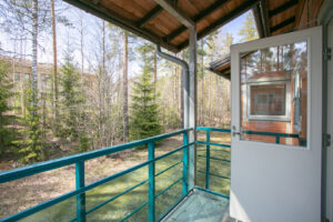 Neulamäentie 3 asunnon parveke, josta on näkymät suoraan metsään. Balcony of apartment at Neulamäentie 3, with a direct view of the forest.